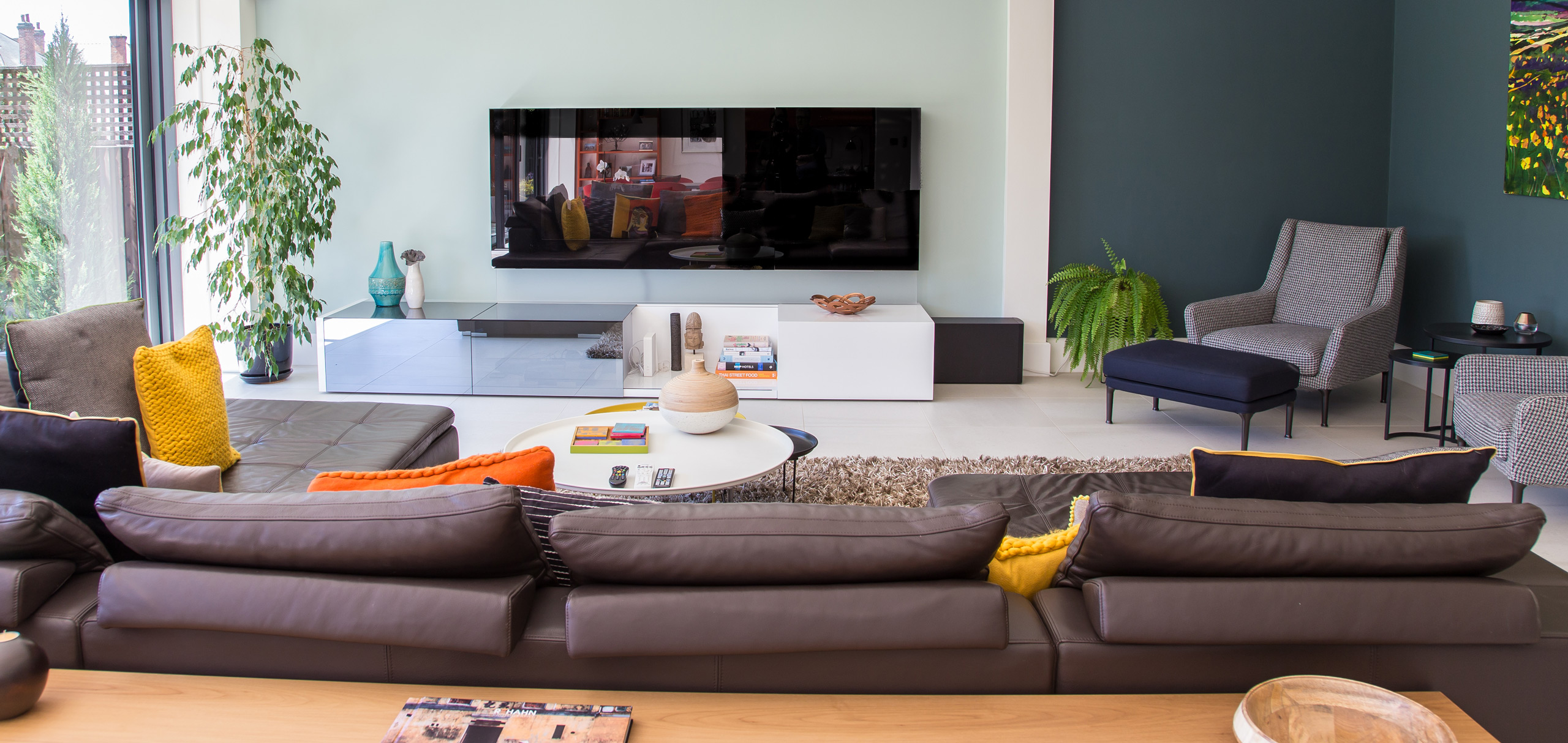 Living room with bold wall colours and brown sofa