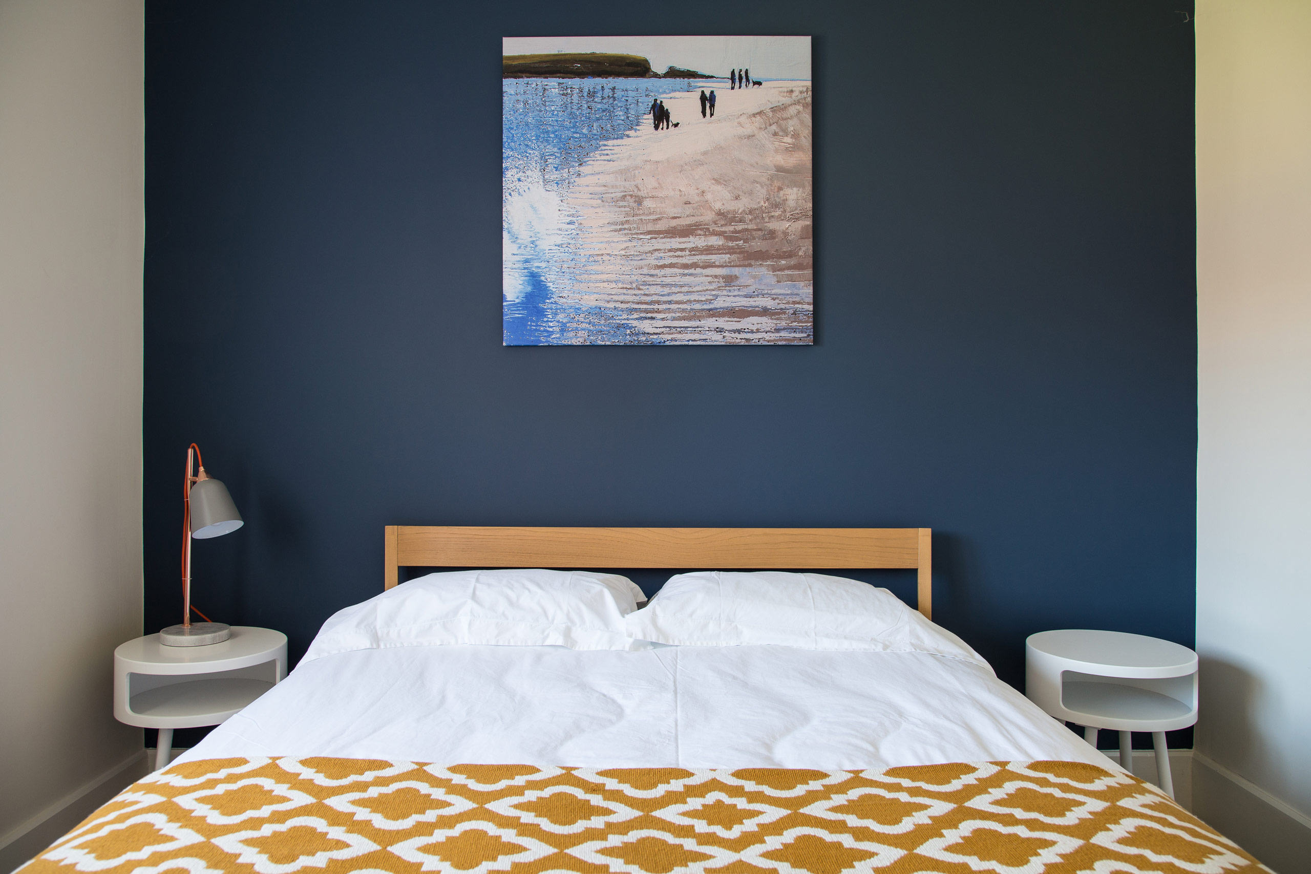 Bedroom with oak bed and dark blue wall